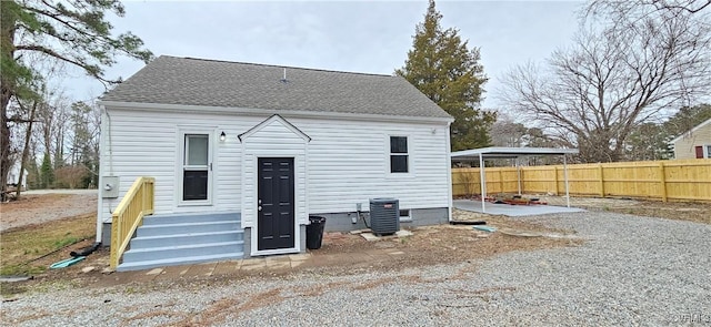 back of property featuring central AC, fence, a patio, and roof with shingles