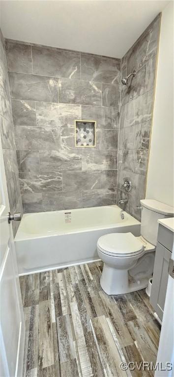 full bath with shower / bathtub combination, vanity, toilet, and wood finished floors