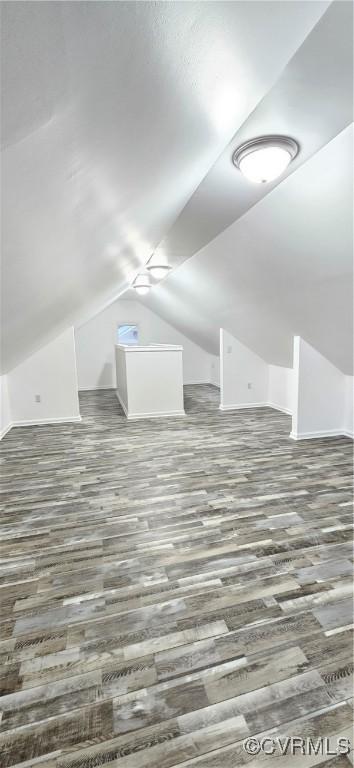 additional living space featuring lofted ceiling and wood finished floors