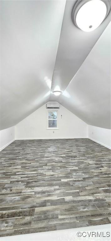 additional living space featuring vaulted ceiling and wood finished floors