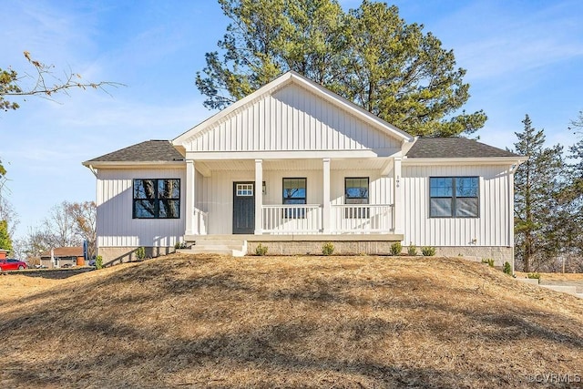 modern farmhouse style home featuring covered porch, a shingled roof, and board and batten siding