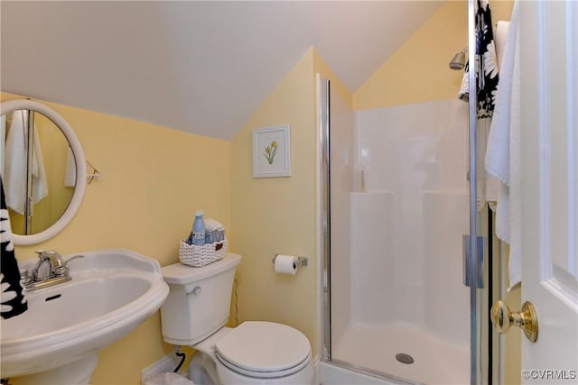 full bathroom with toilet, a stall shower, vaulted ceiling, and a sink