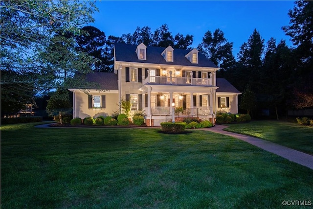 view of front of house featuring a front yard, covered porch, and a balcony