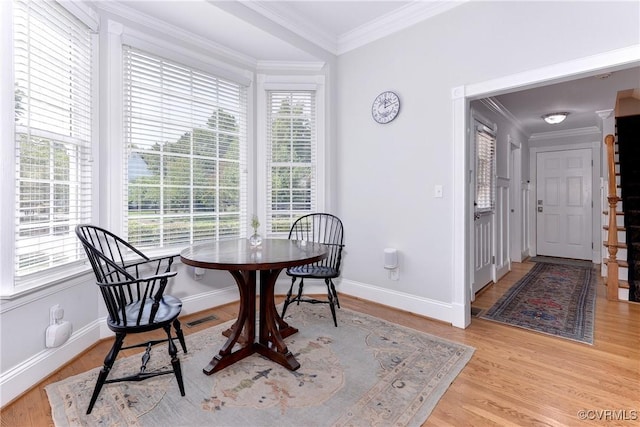 dining room featuring light wood-type flooring, visible vents, baseboards, and crown molding