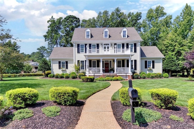 colonial-style house featuring a porch, a front lawn, and a balcony