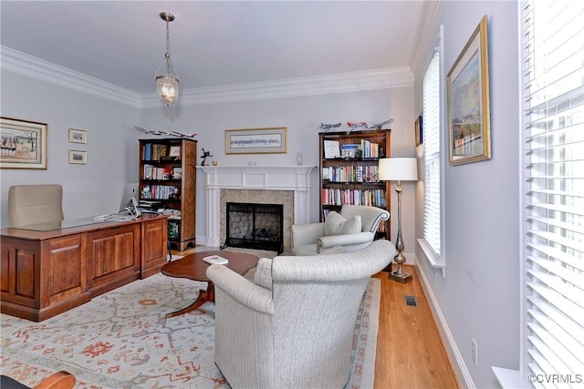 living area with ornamental molding, a fireplace, light wood-style flooring, and visible vents