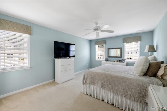 bedroom with a ceiling fan, light colored carpet, and baseboards