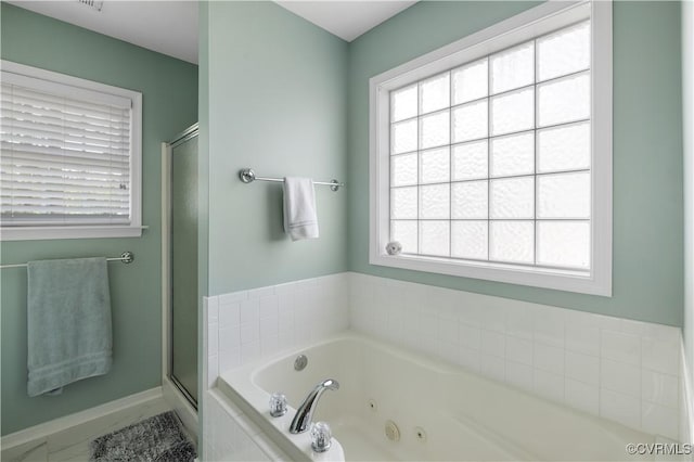 full bath with a jetted tub, a shower stall, and baseboards