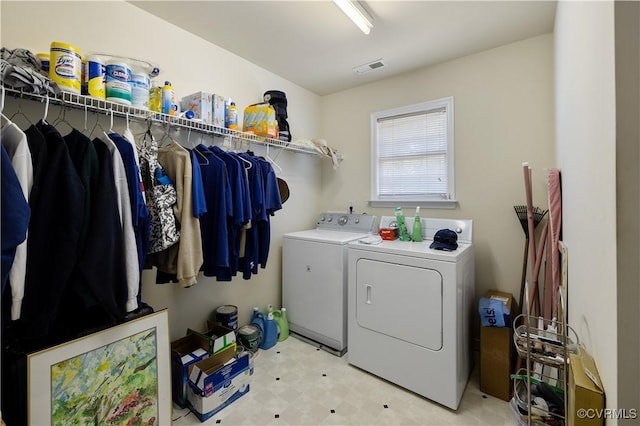 clothes washing area with laundry area, visible vents, light floors, and separate washer and dryer