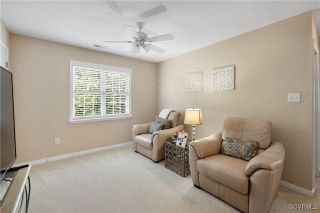 sitting room featuring baseboards, visible vents, a ceiling fan, and light colored carpet