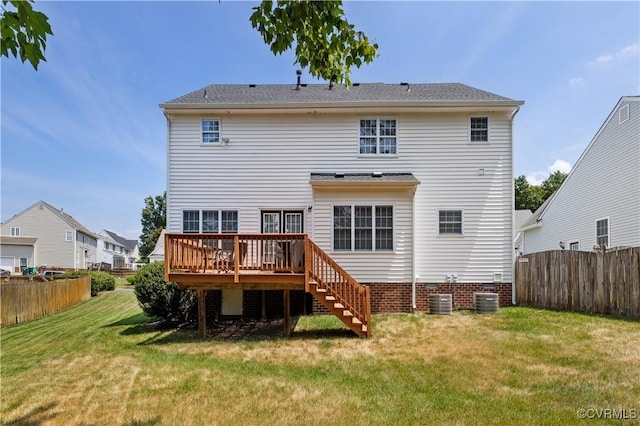 rear view of property with a fenced backyard, a lawn, a deck, and stairs