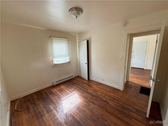 unfurnished bedroom with baseboards, visible vents, a baseboard heating unit, and wood finished floors