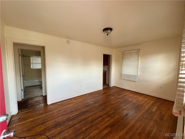 spare room with dark wood-style floors and baseboards