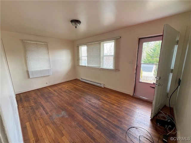 unfurnished room with baseboards, a baseboard heating unit, and hardwood / wood-style floors