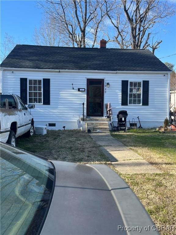 view of front of house with entry steps, roof with shingles, crawl space, a front lawn, and a chimney