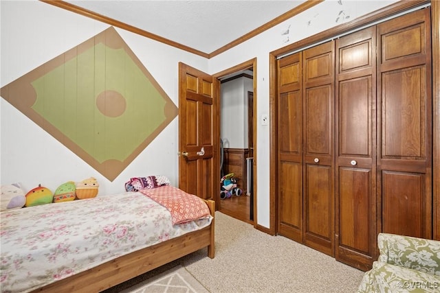 carpeted bedroom with ornamental molding and a closet