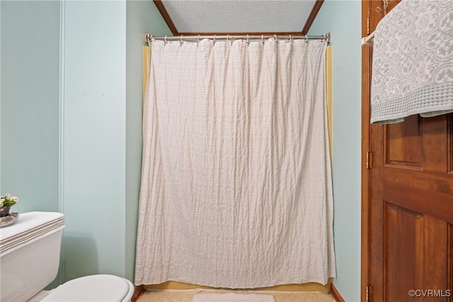 full bath featuring baseboards, a shower with shower curtain, toilet, crown molding, and a textured ceiling