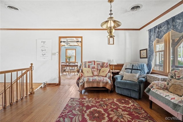 living room with ornamental molding, hardwood / wood-style floors, a textured ceiling, and visible vents