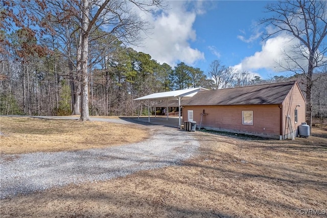 exterior space with driveway, a carport, and central AC unit