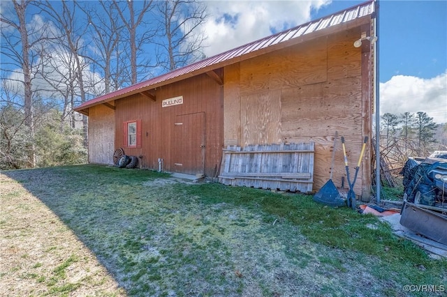 view of property exterior with metal roof and a yard