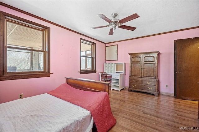 bedroom featuring light wood-style floors, baseboards, and crown molding