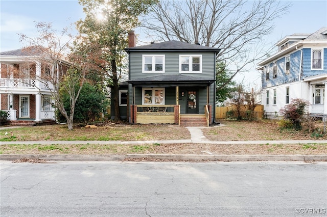 view of front of home featuring a chimney and a porch