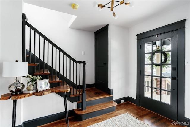 foyer entrance with baseboards, stairway, and wood finished floors