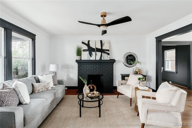 living area with ceiling fan, a fireplace, crown molding, and wood finished floors