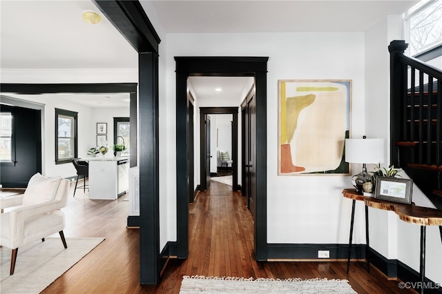 hall with stairway, baseboards, and wood finished floors