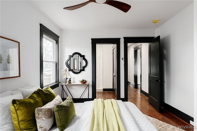 bedroom with ceiling fan, baseboards, and wood finished floors