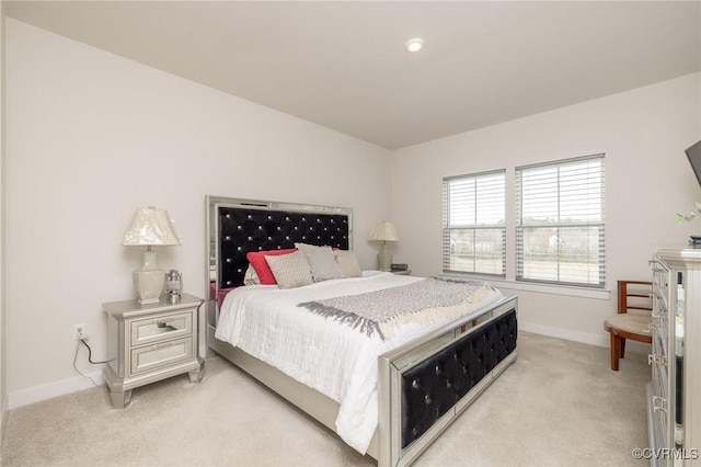 bedroom with light colored carpet and baseboards