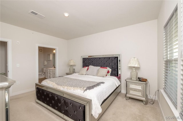 bedroom featuring light carpet, ensuite bathroom, visible vents, and baseboards