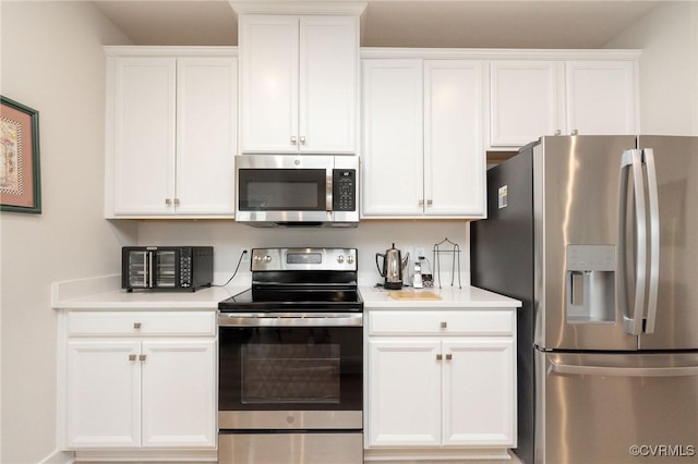 kitchen with stainless steel appliances, light countertops, and white cabinetry