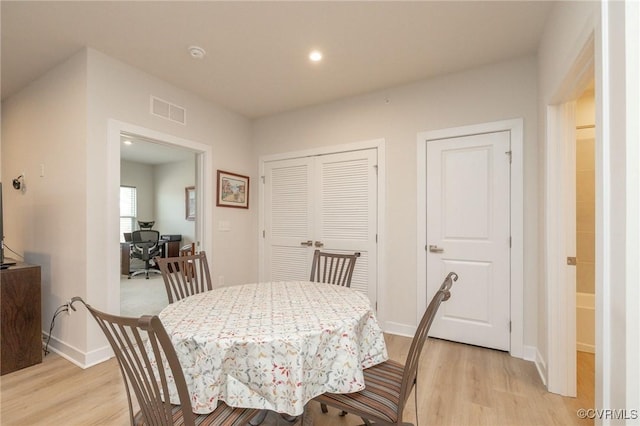 dining space with light wood finished floors, recessed lighting, visible vents, and baseboards