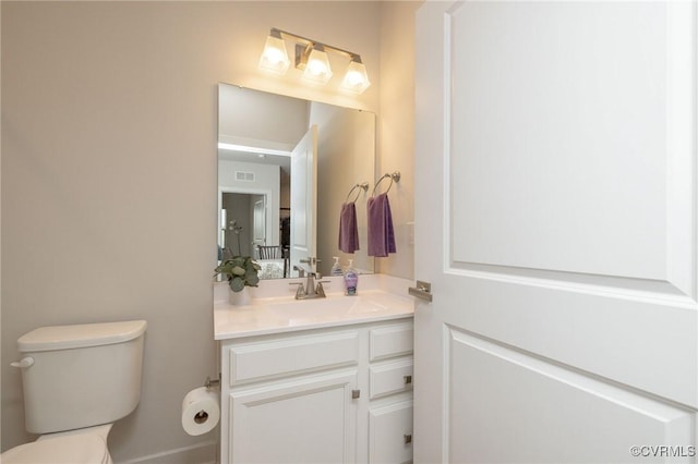 bathroom featuring visible vents, vanity, and toilet