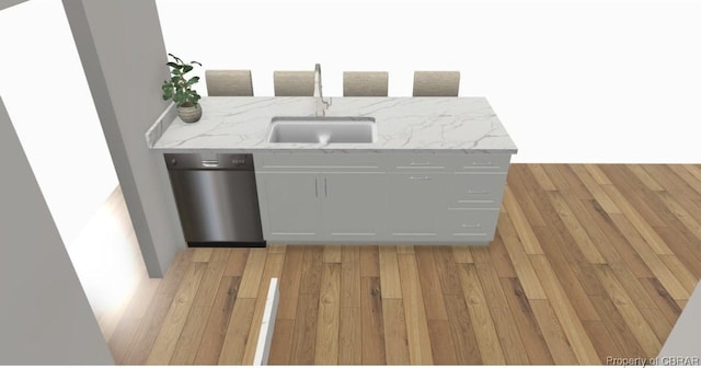 kitchen featuring light stone countertops, light wood-style flooring, and a sink