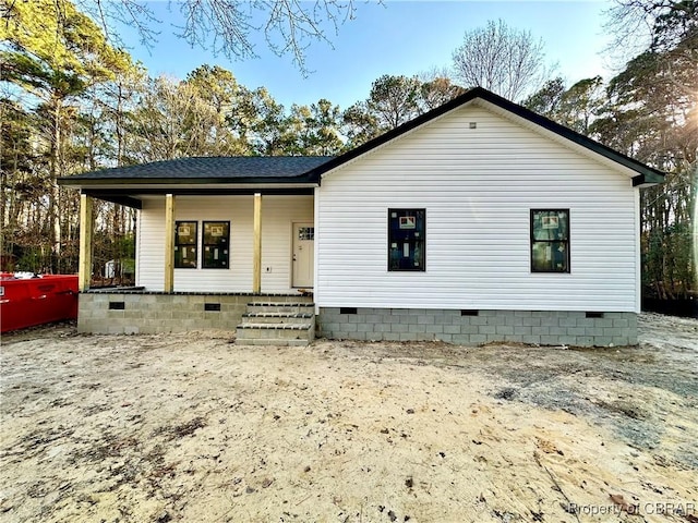 back of house with covered porch, a shingled roof, and crawl space