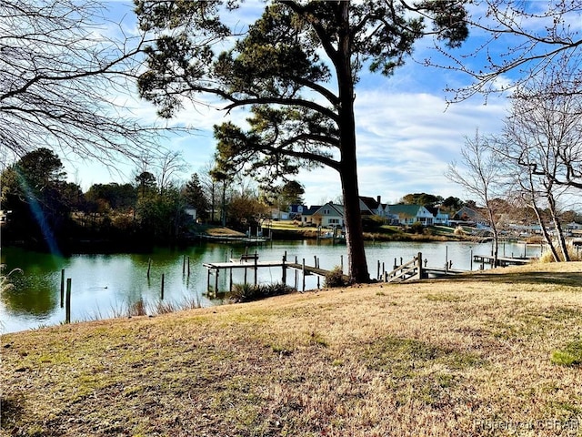 view of dock featuring a water view and a yard
