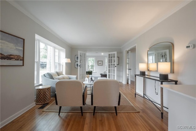 dining area with baseboards, light wood-type flooring, and crown molding