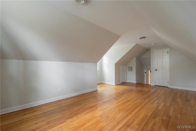 bonus room featuring lofted ceiling, baseboards, visible vents, and light wood finished floors