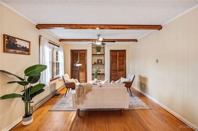 living area with light wood-style floors, a baseboard radiator, and beam ceiling