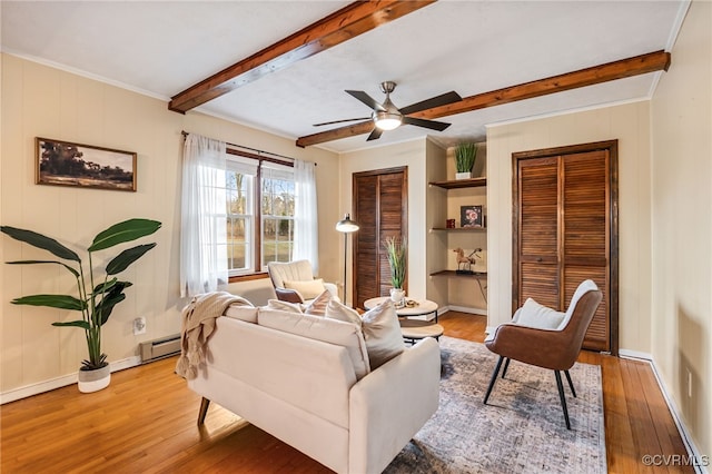 living area with hardwood / wood-style floors, ceiling fan, baseboards, and beamed ceiling