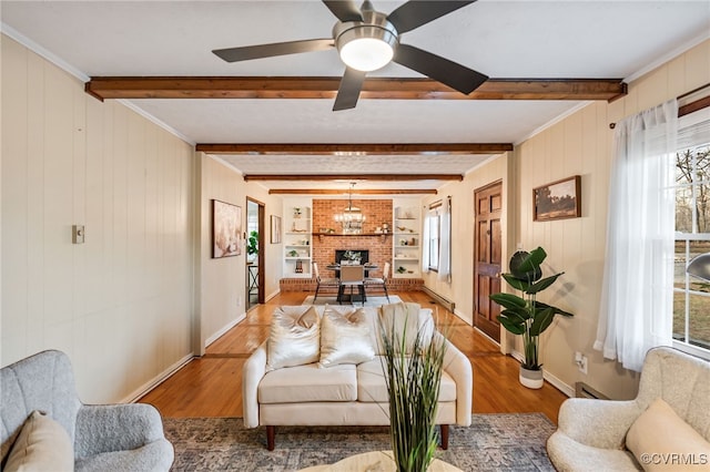 living room featuring ceiling fan, baseboards, beamed ceiling, and wood finished floors