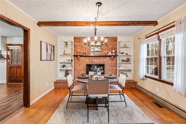 dining space with built in features, a notable chandelier, a textured ceiling, and baseboard heating