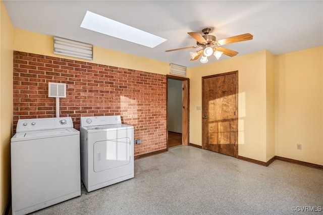 laundry room with laundry area, visible vents, baseboards, brick wall, and washing machine and clothes dryer