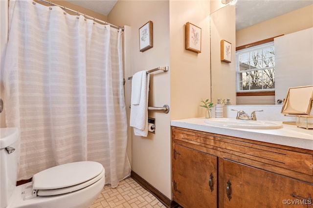 full bath with vanity, toilet, and baseboards