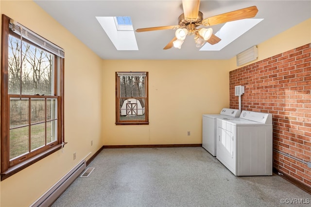 clothes washing area with plenty of natural light, laundry area, washer and clothes dryer, and baseboard heating