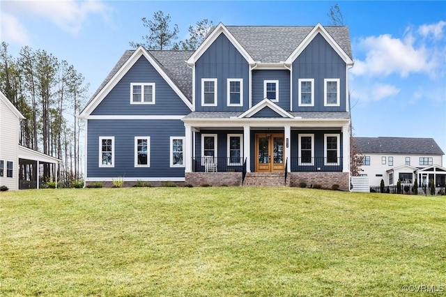 view of front of house featuring a shingled roof, a front lawn, a porch, and board and batten siding