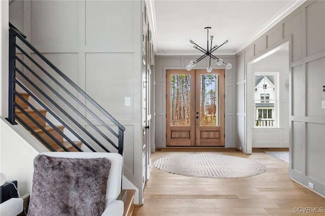 entryway with stairs, crown molding, and a decorative wall