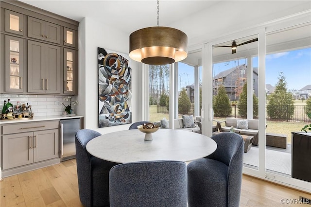 dining area featuring light wood-style floors and bar